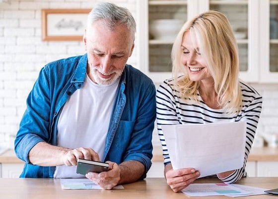 Happy mature family couple managing household budget together Happy mature family couple managing household budget together